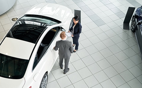 Car showroom with two men talking next to a car