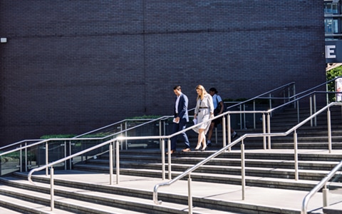 two people walking down a set of external stairs