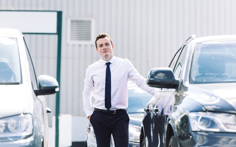 man standing in between two cars