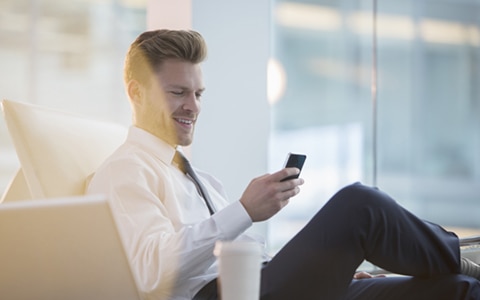 Man sitting looking at phone smiling
