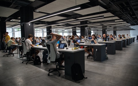 people sitting at modern workbenches