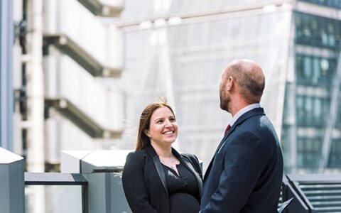 Woman and man standing outside offices having a conversation