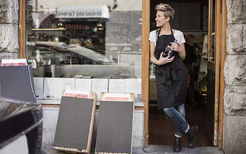 small business owner standing in doorway of restaurant